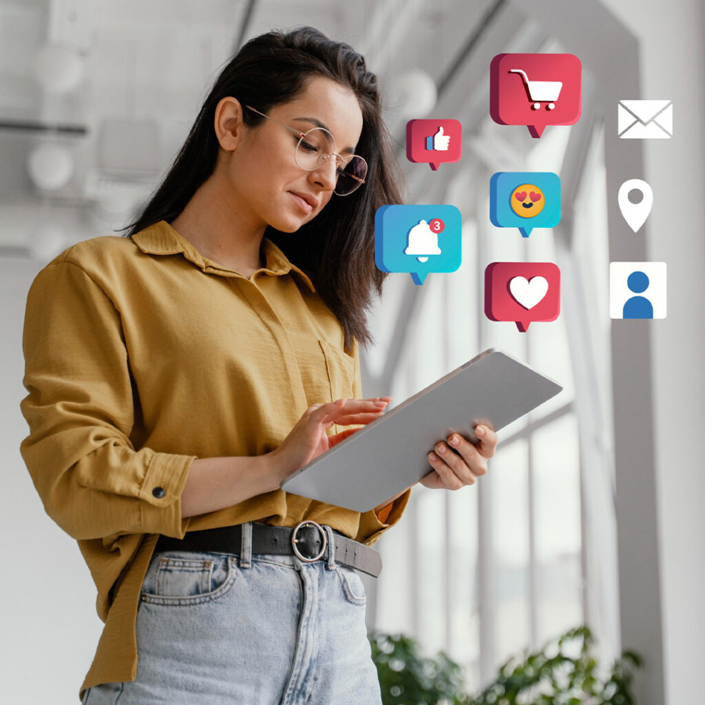 Business woman holding large tablet with engagement icons floating above